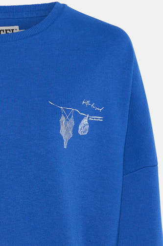 Gilet bleu de Le Fabuleux Marcel de Bruxelles, avec une impression blanche d'une ligne de repère pour le lavage des vêtements.