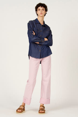 Chemise en jean bleu foncé à manches longues de Le Fabuleux Marcel de Bruxelles, portée avec un pantalon rose et des sandales marron.