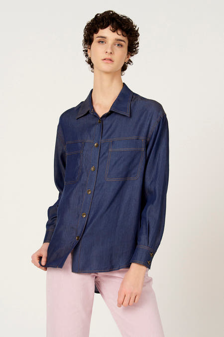 Chemise en jean bleu foncé à manches longues de Le Fabuleux Marcel de Bruxelles, avec poches poitrine et surpiqûres colorées.
