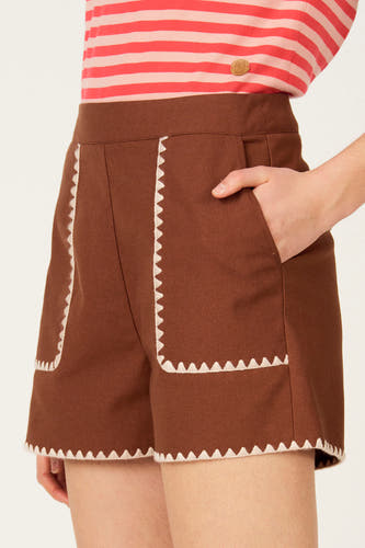 Short marron de Le Fabuleux Marcel de Bruxelles, avec finition zigzag blanche le long des bords et des poches, vue de côté.