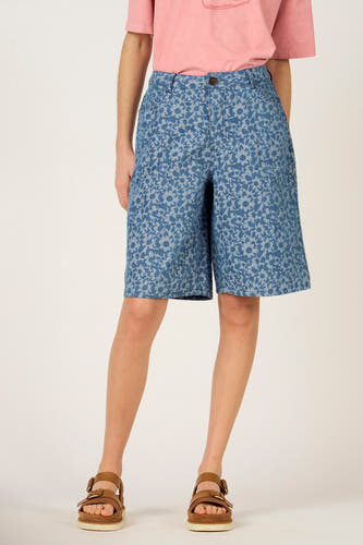 Bermuda en jean bleu, de Le Fabuleux Marcel de Bruxelles, avec motif floral, combiné avec des sandales marron et un t-shirt rose.