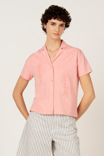 T-shirt rose à manches courtes de Le Fabuleux Marcel de Bruxelles, vu de dos, avec un pantalon rayé.