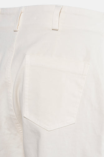 Close-up van een crèmekleurige broek met zak.