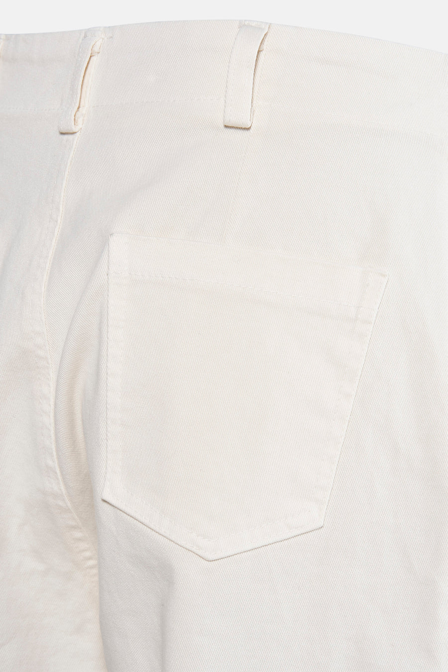 Close-up van een crèmekleurige broek met zak.