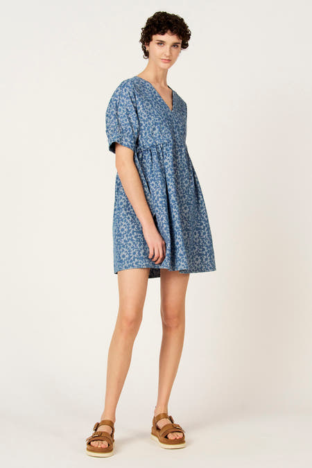 Blauw denim kleedje met korte mouwen van Le Fabuleux Marcel de Bruxelles, met bloempatroon, gedragen met bruine sandalen.
