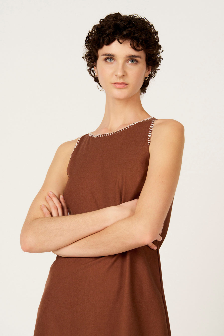 Robe sans manches marron, de Le Fabuleux Marcel de Bruxelles, avec surpiqûres blanches le long de l'encolure et des emmanchures.
