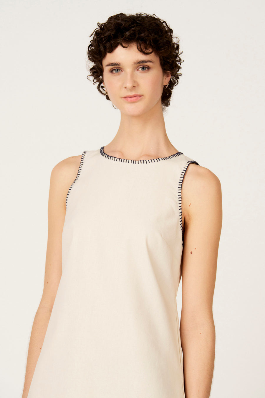 Robe écru sans manches de Le Fabuleux Marcel de Bruxelles, avec coutures bleues le long de l'encolure et des emmanchures.