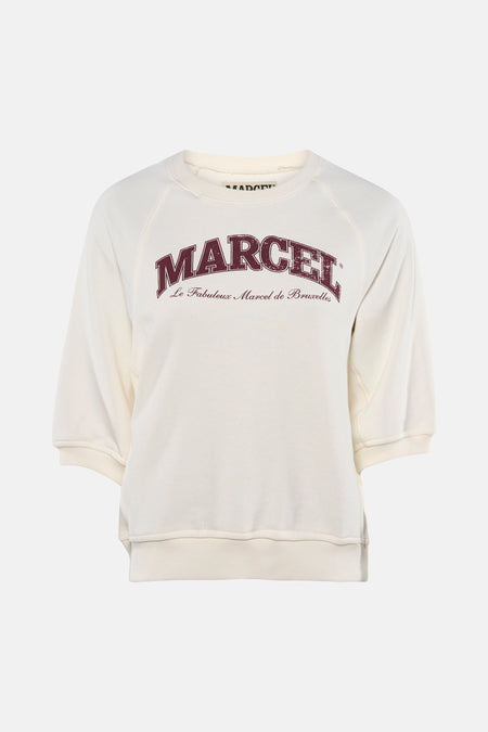 Pull écru à col rond de Le Fabuleux Marcel de Bruxelles, avec imprimé 'MARCEL' bordeaux et manches courtes raglan.