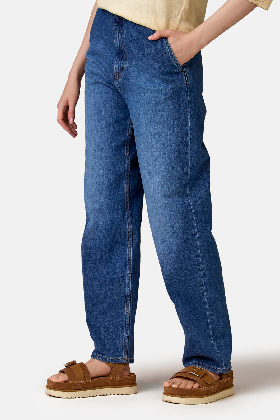 Jeans en denim foncés, de Le Fabuleux Marcel de Bruxelles, avec une coupe décontractée et des sandales marron.
