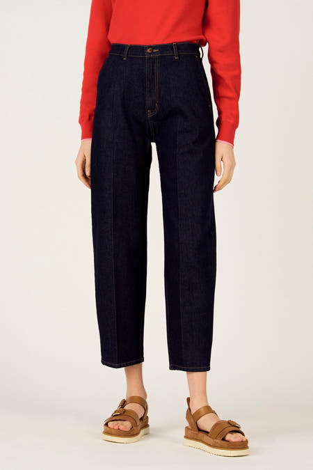 Slim jeans van donkerblauw denim van Le Fabuleux Marcel de Bruxelles, met gele stiksels en een rode trui.
