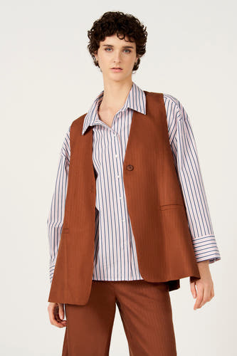 Blazer marron de Le Fabuleux Marcel de Bruxelles avec un motif à chevrons subtil, porté sur une chemise rayée, vue arrière.