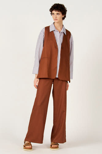 Blazer marron de Le Fabuleux Marcel de Bruxelles, porté sur une chemise rayée et un pantalon marron.