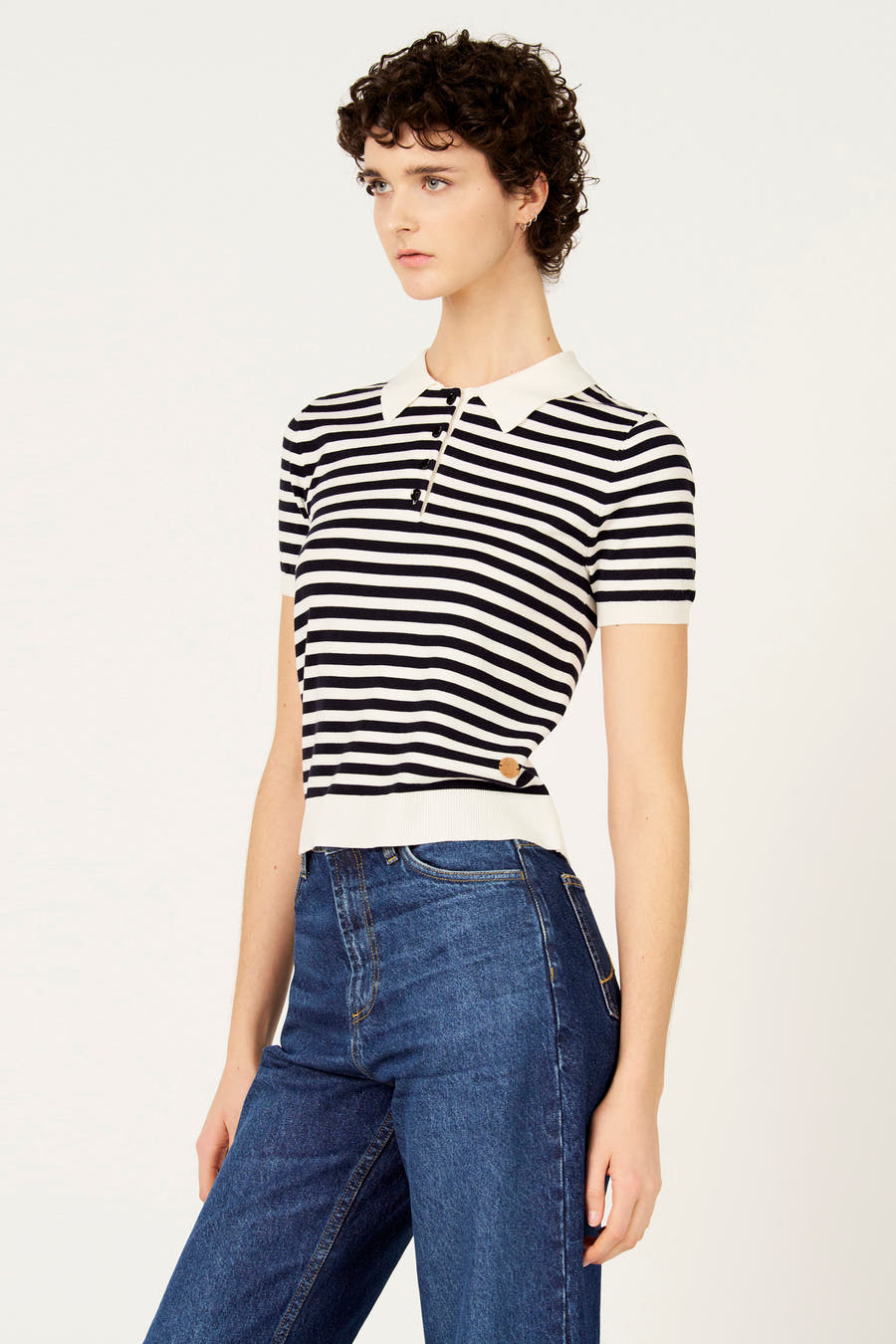 Blauwe trui met ronde hals van Le Fabuleux Marcel de Bruxelles, met een gestreept patroon en een polokraag, gedragen met een donkere jeans.
