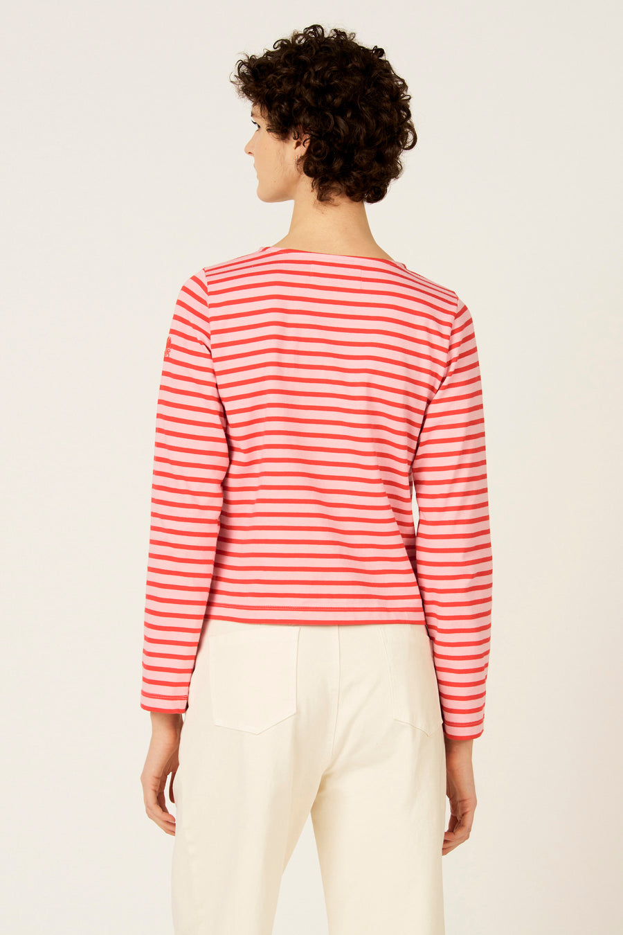 Rood-roze gestreept T-shirt met lange mouwen van Le Fabuleux Marcel de Bruxelles, gezien van achteren, gedragen met crèmekleurige broek.
