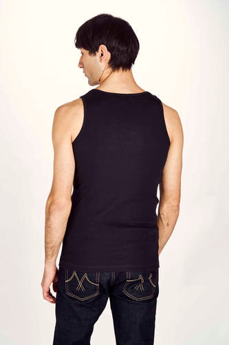 Zwart tanktop van Le Fabuleux Marcel de Bruxelles, geribbelde textuur, gezien van achteren met donkere jeans.
