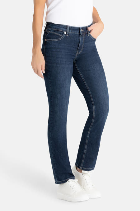 Jean droit en denim bleu moyen de MAC, avec des coutures légères et porté avec des baskets blanches et un t-shirt blanc.