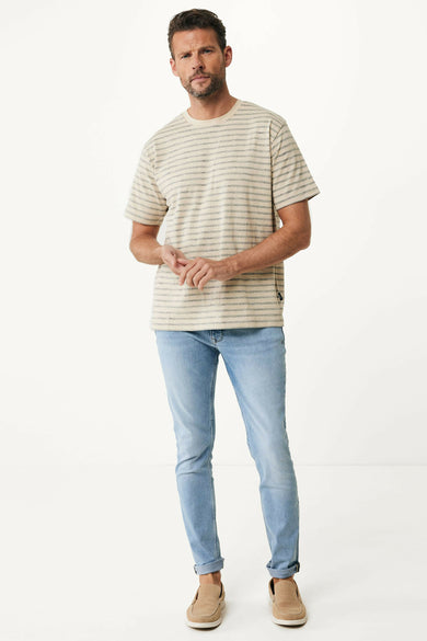 T-shirt rayé bleu de MEXX, porté avec des jeans et des bottes en cuir.