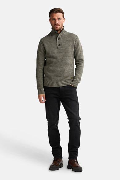 T-shirt vert avec col rond de Petrol Industries®, avec détail de bouton et jeans noirs et chaussures marrons.