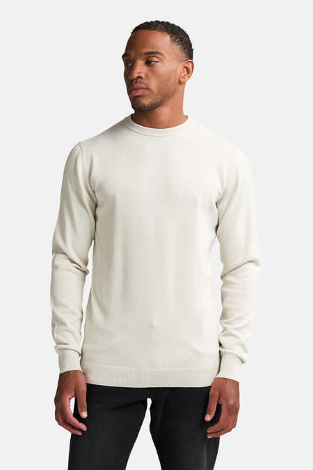 T-shirt écru avec col rond de Petrol Industries, vu de l'arrière, porté avec des jeans foncés et des chaussures crème.
