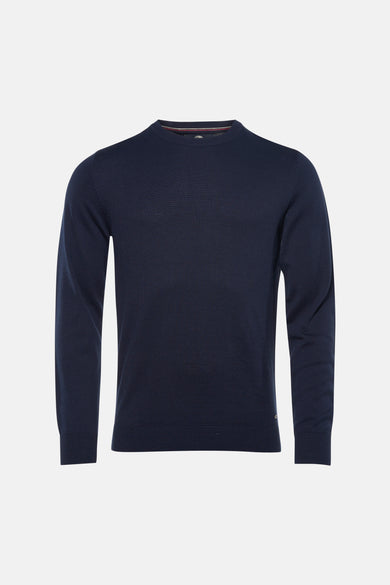 Pull bleu à col rond de Petrol Industries®, porté avec un jean clair et des baskets blanches.
