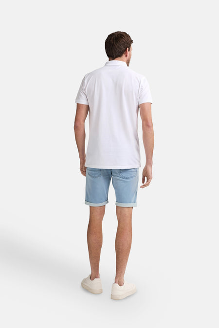 Polo blanc à manches courtes de Petrol Industries, dos, combiné avec des shorts en denim bleu clair et des baskets crème.