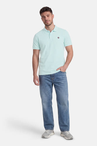 Polo verte à manches courtes verte de Petrol Industries®, portée avec un jean et des baskets grises.
