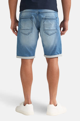Short en jean bleu de Petrol Industries, vu de dos, avec ourlets retroussés et baskets blanches.