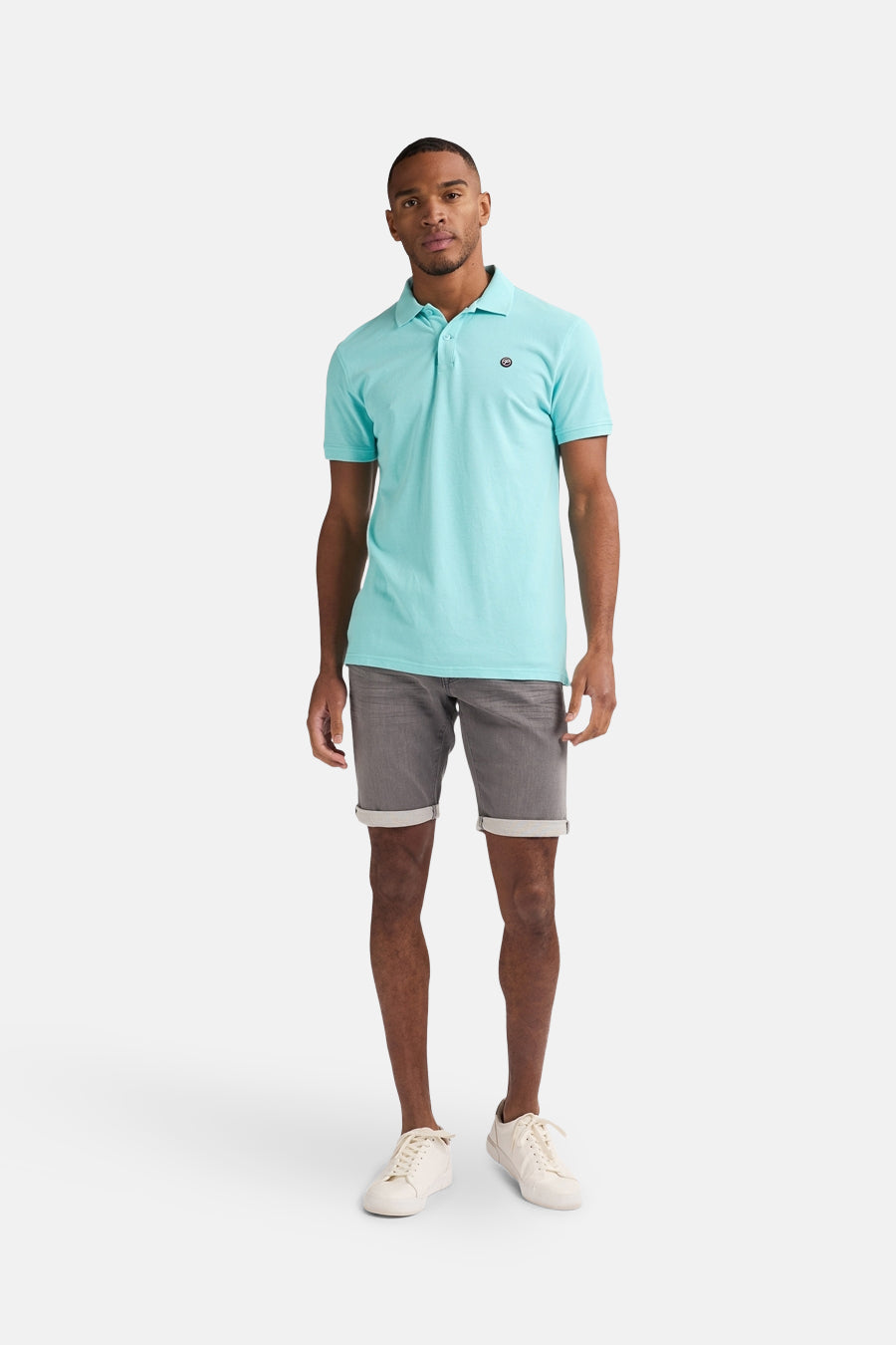Grijze jeansshort van Petrol Industries®, met omgeslagen pijpen en gedragen door een model met een lichtblauw poloshirt.
