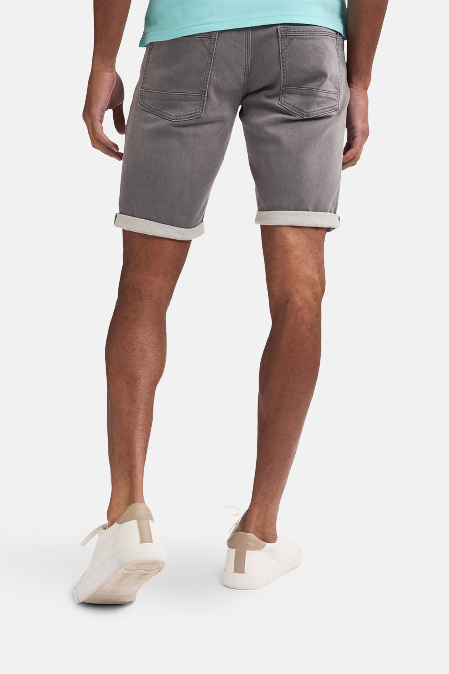Grijze jeansshort van Petrol Industries® met omgeslagen pijpen, gezien van achteren, met witte schoenen.