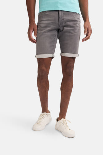 Jean short gris de Petrol Industries®, avec des poches pliées et associé à des baskets légères.