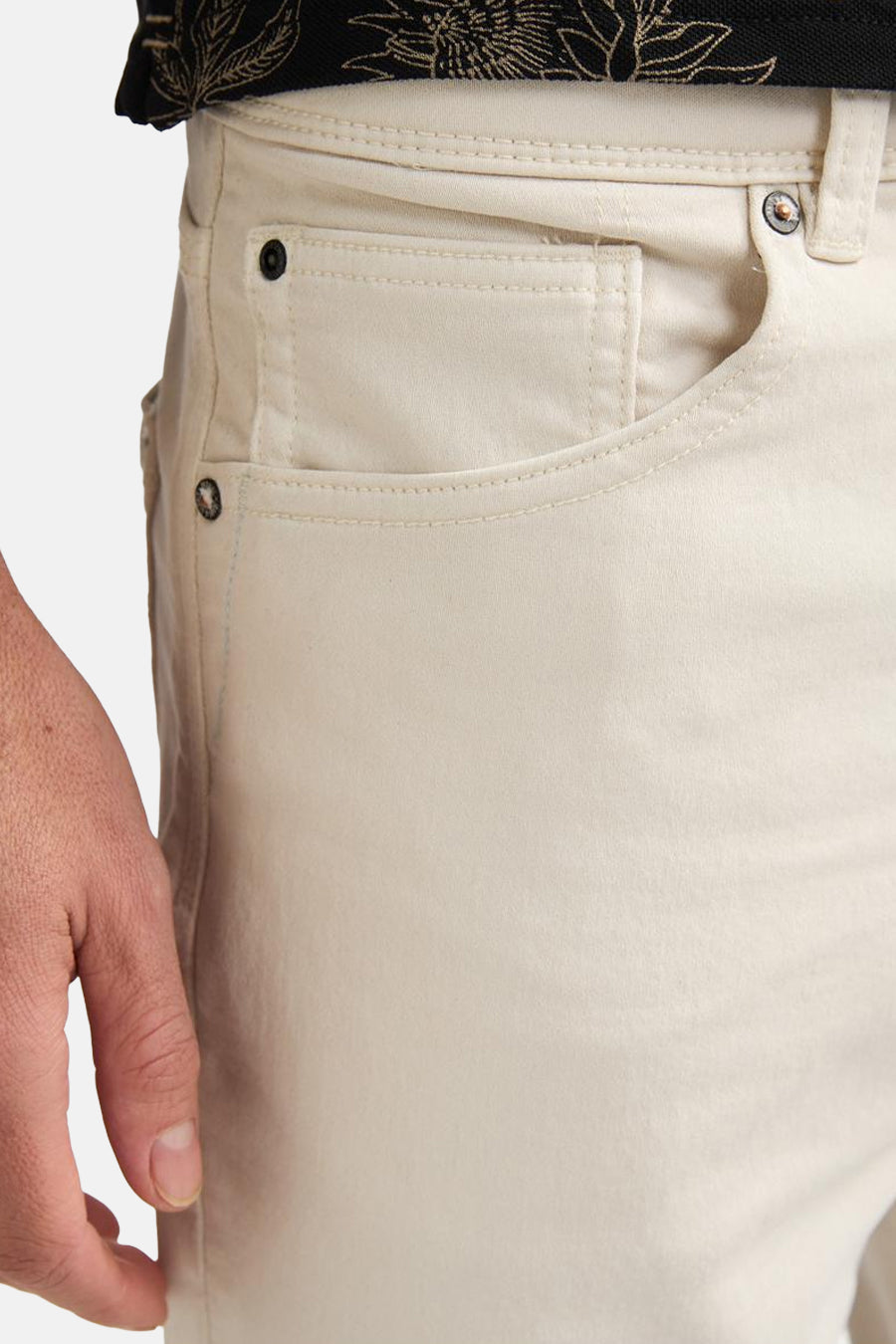 Short écru de Petrol Industries, gros plan sur les poches avant avec rivets, porté avec une chemise à motif noir.