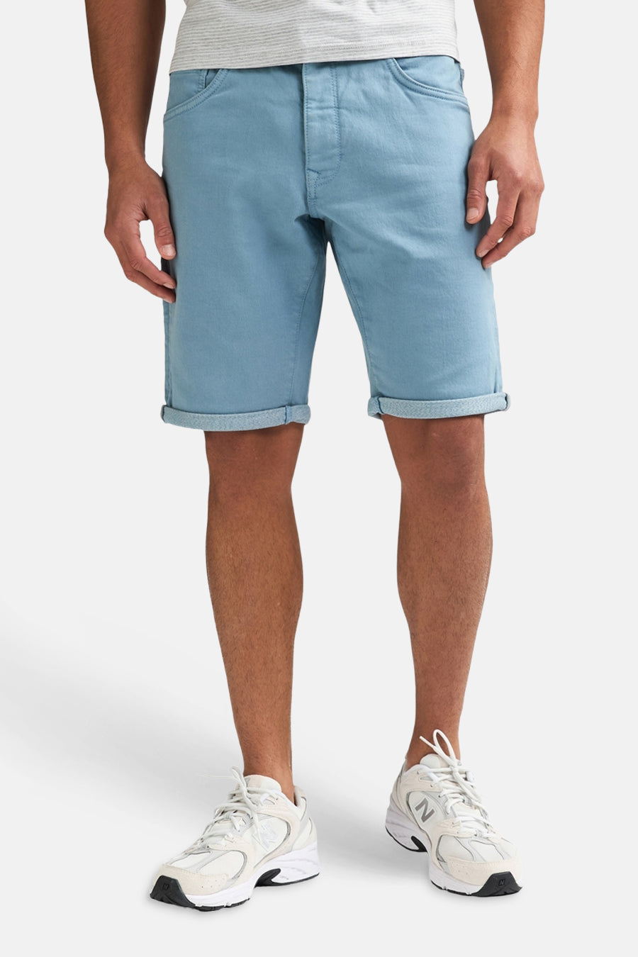 Short bleu de Petrol Industries® avec ourlets retroussés, porté par un homme avec un t-shirt gris rayé et des baskets blanches.