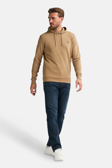 Gilet écru avec un chapeau de Petrol Industries, porté avec des jeans bleus foncés et des baskets blanches.