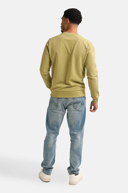 Sweater vert de Petrol Industries, vu de l'arrière, porté avec des jeans et des baskets crème.