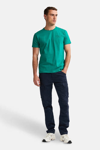 Pantalon cargo bleu de Petrol Industries®, associé à un T-shirt vert et des baskets blanches.