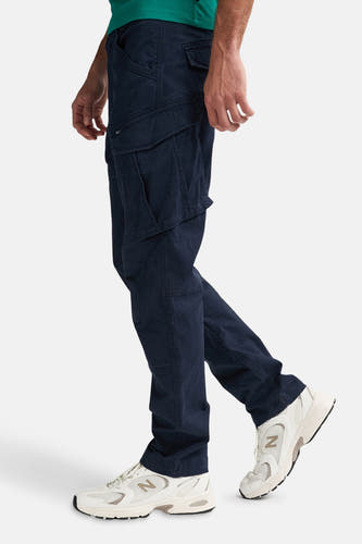 Pantalon cargo bleu de Petrol Industries®, avec une poche brodée, porté avec des baskets blanches.