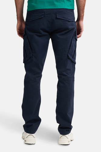 Pantalon de travail bleu de Petrol Industries®, vu de derrière, avec des poches et des baskets blanches.