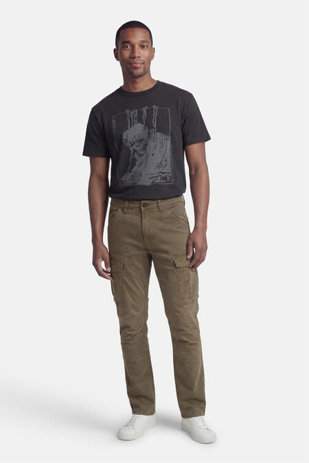 Groene cargobroek van Petrol Industries® met cargozakken, gedragen met een zwart T-shirt en witte sneakers.

