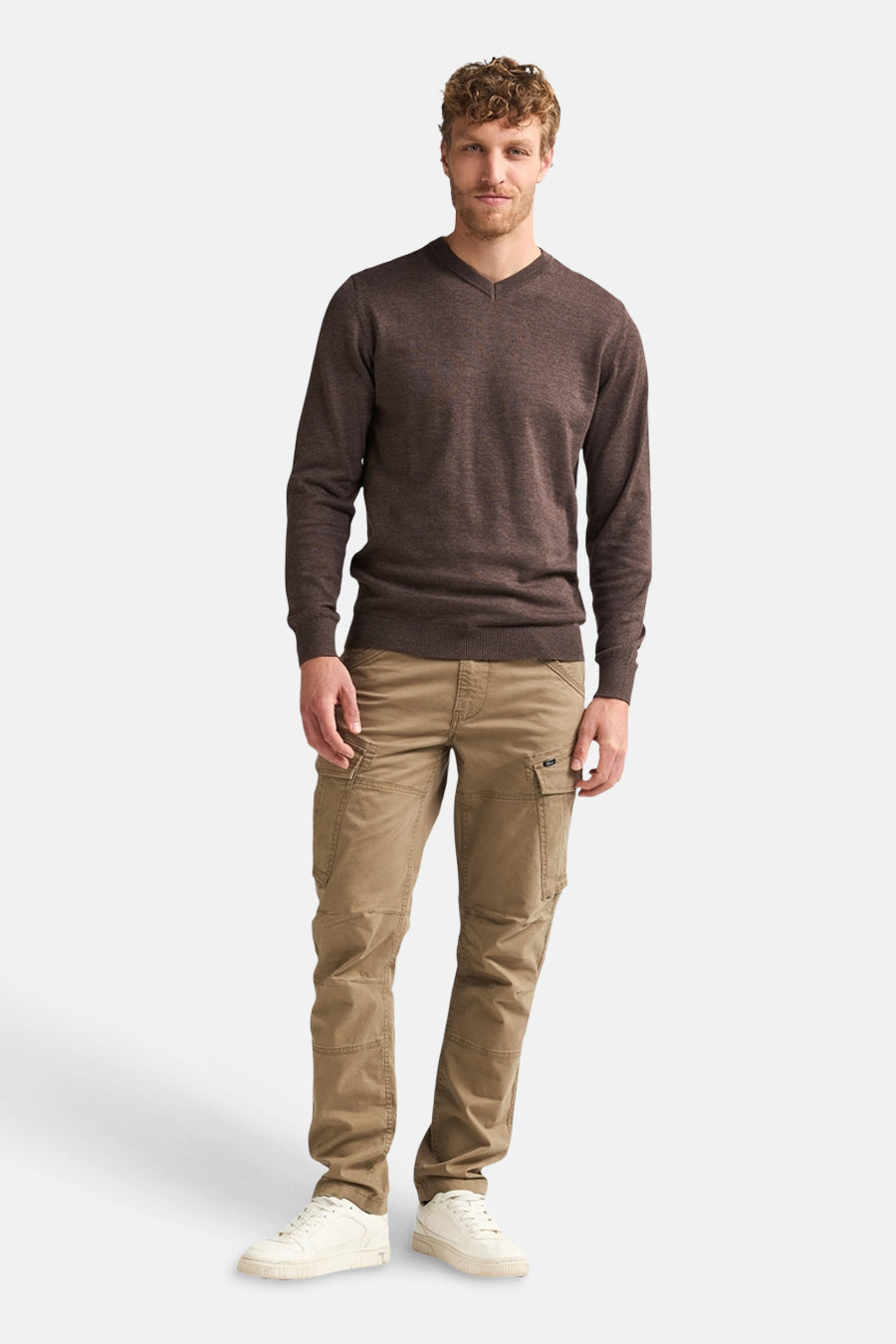 Bruine cargo broek van Petrol Industries® met zakken, gedragen met donkere trui en witte sneakers, front view.