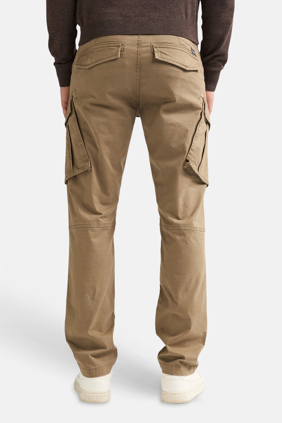 Bruine cargobroek van Petrol Industries®, achterzijde met grote zijzakken en elastische zoom, gedragen met donkere trui en witte sneakers.
