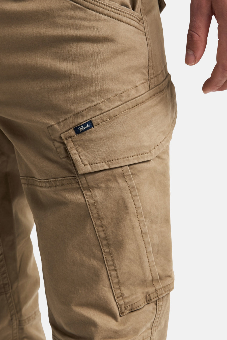 Bruine cargobroek van Petrol Industries® met grote zakken en stoffen label, close-up van de zijzak