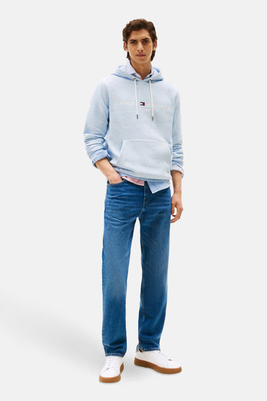 Pull-over bleu de TOMMY HILFIGER, porté avec un chemisier à manches longues et un jean.