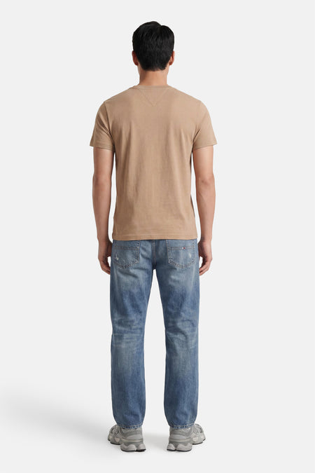 Beige korte mouwen T-shirt van TOMMY HILFIGER, achterzijde, gladde stof, model draagt blauwe jeans en grijze sneakers