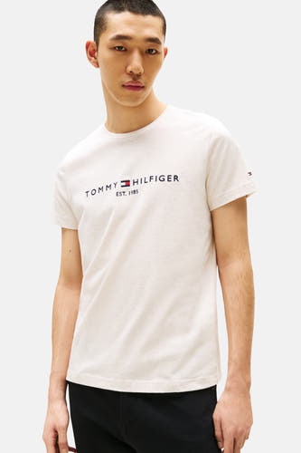 T-shirt beige à manches courtes de TOMMY HILFIGER, avec logo sur la poitrine et pantalon noir uni.