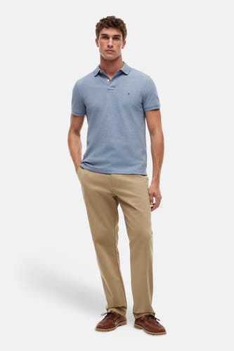 Polo bleu TOMMY HILFIGER à manches courtes et boutons, porté avec un pantalon kaki et des chaussures marron.