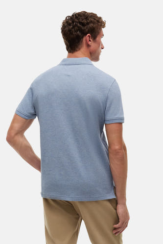 Polo bleu TOMMY HILFIGER en tissu chiné, vue arrière sur un homme avec un pantalon kaki.