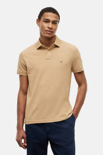 Polo beige de TOMMY HILFIGER avec texture piquée, col classique, deux boutons et le logo de la marque sur la poitrine.