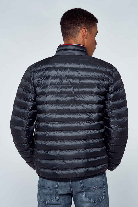 Veste de pluie bleue TOMMY JEANS, vue de derrière, avec des coutures horizontales et une coupe cintrée.