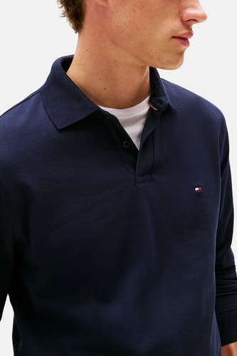 Polo bleu de TOMMY HILFIGER, avec des manches longues et un logo brodé sur la poitrine.
