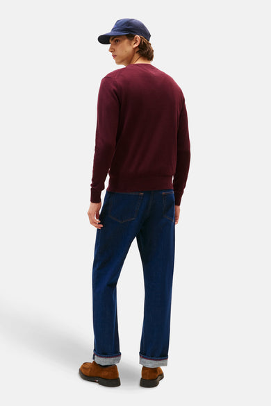 Veste Bordeaux TOMMY HILFIGER avec col rond, portée avec un chapeau bleu marine, des jeans noirs et des chaussures marrons, dos.